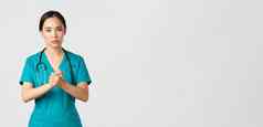 科维德医疗保健工人流感大流行概念充满希望的严肃的表情亚洲护士医生有关脸握紧手支持冠状病毒白色背景