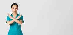 科维德医疗保健工人流感大流行概念不高兴严肃的表情有关亚洲女医生显示交叉手势停止禁止禁止危险的行动白色背景