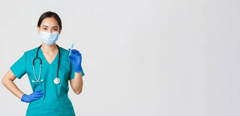 科维德冠状病毒疾病医疗保健工人概念微笑自信亚洲女护士实习医生风云医疗面具持有注射器疫苗疫苗接种拍摄白色背景