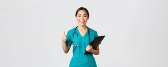 医疗保健工人防止病毒检疫运动概念微笑漂亮的亚洲医生女实习生实习医生风云显示翘拇指持有剪贴板带积极的结果白色背景