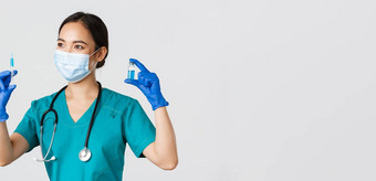 科维德冠状病毒疾病医疗保健工人概念一边视图微笑漂亮的亚洲医生护士实习医生风云注射器疫苗持有灯泡站白色背景