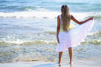 黑色的女孩走海岸海滩穿美丽的长衣服