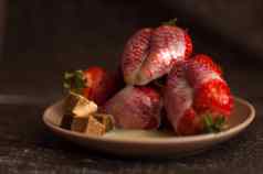 红色的成熟的草莓轮板狗糖块融化了白色巧克力