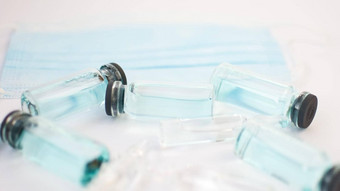 瓶疫苗前视图玻璃灯泡透明的蓝色的液体说谎白色背景全球疫苗接种概念