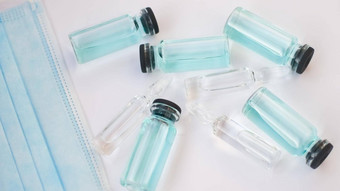 瓶疫苗前视图玻璃灯泡透明的蓝色的液体说谎白色背景全球疫苗接种概念