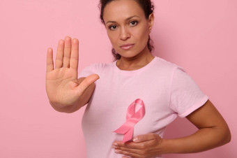 自信肖像模糊女人穿粉红色的t恤<strong>癌症</strong>意识丝带焦点女人的手手势停止孤立的粉红色的背景复制空间