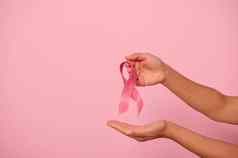女人手持有粉红色的丝带象征世界乳房癌症意识一天10月女人的健康医疗概念10月粉红色的一天世界癌症一天国家癌症幸存者一天
