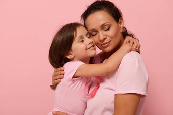 美丽的爱的妈妈。女儿拥抱穿粉红色的衣服粉红色的丝带象征世界乳房癌症意识一天10月世界癌症一天国家癌症幸存者一天