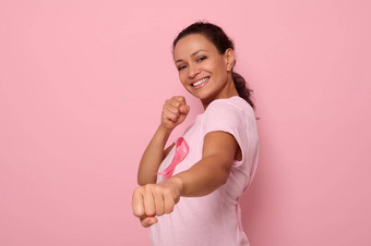 漂亮的女人粉红色的t恤癌症意识丝带站战斗的立场马克战斗癌症荣誉10月微笑相机彩色的背景复制空间