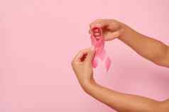特写镜头女人的手持有粉红色的丝带象征世界乳房癌症意识一天10月女人的健康医疗概念国家癌症幸存者一天孤立的复制空间