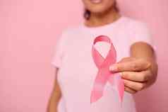 特写镜头女成人手持有粉红色的丝带世界癌症一天乳房腹部癌症意识10月粉红色的一天彩色的背景复制空间乳房癌症支持概念