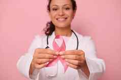 软焦点乳房癌症意识粉红色的丝带手模糊混合比赛女医生白色医疗外套孤立的彩色的背景10月世界一天战斗乳房癌症