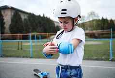 波特罗特英俊的男孩滑板者穿安全头盔把保护扶手滑冰