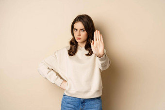 停止自信女人显示扩展手臂棕榈禁止禁止smth阻塞站米色背景