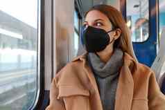 年轻的深思熟虑的女人医疗面具断续器火车窗口概念旅行公共运输流感大流行