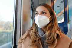 关闭年轻的夫人穿保护医疗面具断续器公共运输窗口