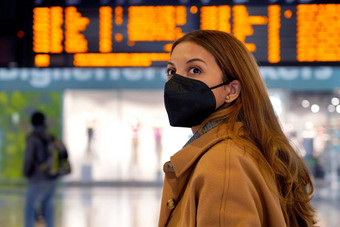 旅行者女人穿黑色的保护面具断续器机场保护病毒年轻的女人时间表信息<strong>离职</strong>移民