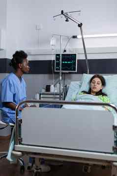 护士坐着医院病房监控病人重要器官屏幕写作医疗报告