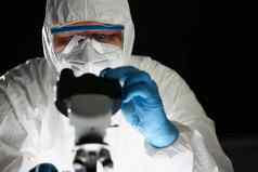 集中人化学家蓝色的保护手套显微镜化学实验室