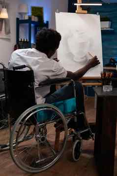年轻的艺术家设计师轮椅画花瓶