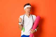 概念锻炼健身房生活方式图像动机快乐中年健身的家伙实现目标使拳头泵持有瑜伽席跳过绳子