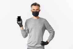 概念科维德社会距离生活方式图像自信中年男人。眼镜医疗面具手套显示智能手机屏幕演示应用程序