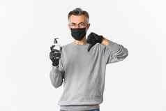 概念冠状病毒生活方式检疫肖像中年男人。医疗面具手套推荐防腐剂显示手洗手液责备白色背景
