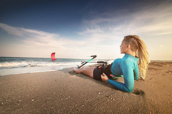 有吸引力的高加索人女人长发绺头潜水服谎言桑迪海滩持有风筝水体育风筝冲浪者假期复制空间