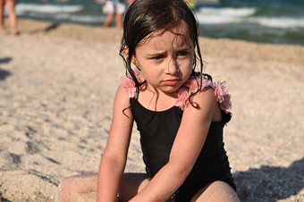 头像肖像可爱的心烦意乱婴儿女孩湿头发泳衣坐着桑迪海滩海背景孩子们情绪夏天假期概念