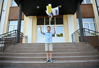 小学学生男孩喜乐结束教训学校抛出手册笑微笑幸福的站楼梯背景学校机构