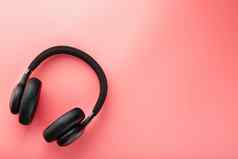 黑色的蓝牙耳机粉红色的背景前视图入耳式耳机dj