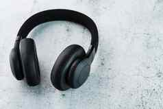 无线黑色的耳机灰色的石头背景视图入耳式耳机玩游戏听音乐跟踪