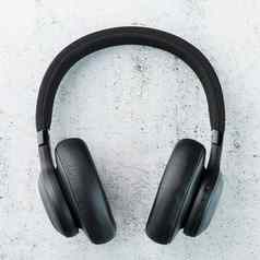 无线黑色的耳机灰色的石头背景视图入耳式耳机玩游戏听音乐跟踪