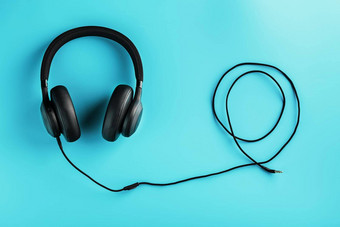 黑色的耳机线蓝色的背景视图入耳式耳机玩游戏听音乐跟踪
