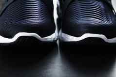 黑色的白色超现代化的体育运动鞋黑色的背景