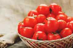 新鲜的红色的西红柿柳条篮子木表格成熟的多汁的樱桃西红柿滴水分灰色的木表格布粗麻布乡村风格