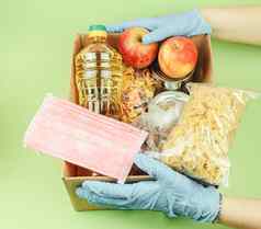 志愿者保护手套捐赠食物盒子绿色背景食物交付病毒保护捐赠怜悯概念