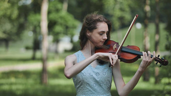 年轻的女孩戏剧小提琴城市公园