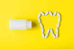 钙维生素形式牙泄漏白色Jar黄色的背景