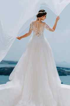 浪漫的美丽的新娘白色衣服摆姿势阳台海山背景