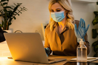 年轻的女人高加索人穿手套手面具脸工作首页办公室工作移动PC一天防止病毒传播疫<strong>情</strong>检疫预防
