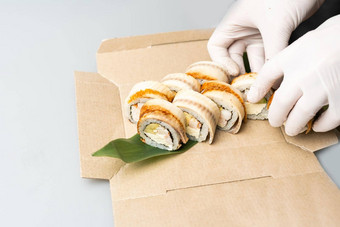 烹饪手使日本寿司卷日本老板工作准备美味的寿司卷鳗鱼鳄梨开胃的日本食物