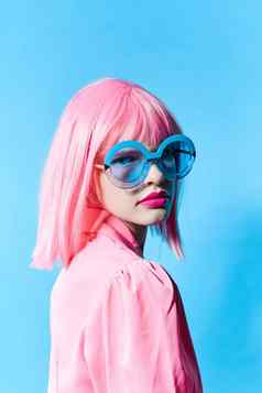 漂亮的女人蓝色的眼镜穿粉红色的假发工作室模型不变的