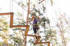 女孩攀爬冒险公园的地方宽各种元素绳子攀爬练习障碍课程铁链