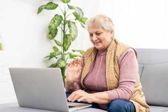 成熟的老成人女人看培训网络研讨会移动PC工作首页办公室中间岁的女商人采取笔记电脑技术