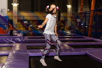 孩子跳蹦床在室内操场上活跃的蹒跚学步的女孩有趣的体育运动中心