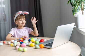 漂亮的女孩穿兔子耳朵绘画复活节鸡蛋首页冠状病毒科维德爆发孩子移动PC厨房在线视频调用朋友