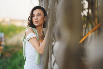 亚洲女人摆姿势烟草干燥流穿白色衣服绿色<strong>长筒靴</strong>