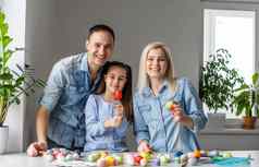 快乐复活节家庭妈妈。父亲孩子们有趣的油漆装修鸡蛋假期