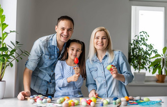 快乐复活节家庭妈妈。父亲孩子们有趣的油漆装修鸡蛋假期